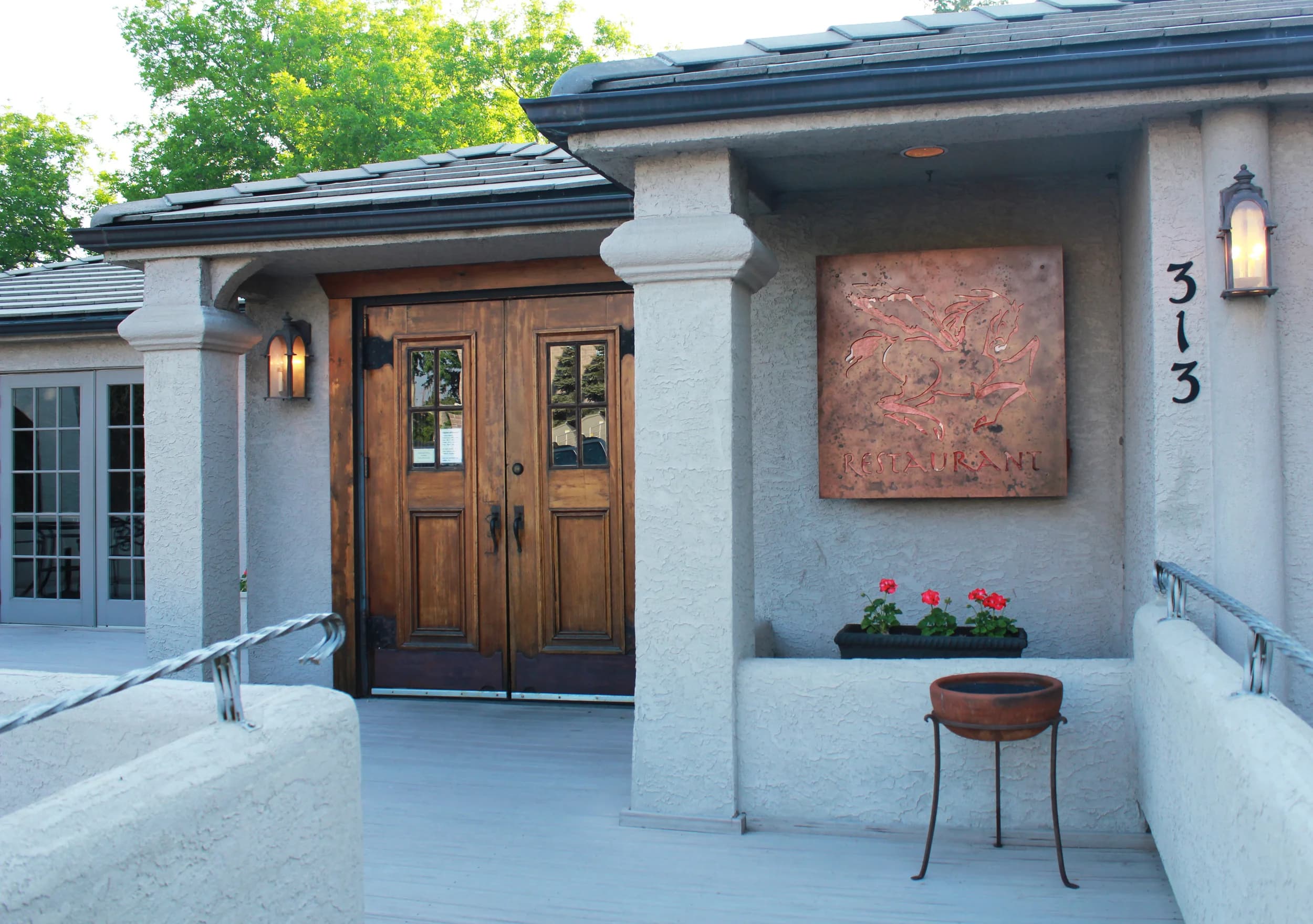 Entrance to Pegasus Restaurant in Castle Rock, Colorado, with its copper Pegasus sign and wooden doors