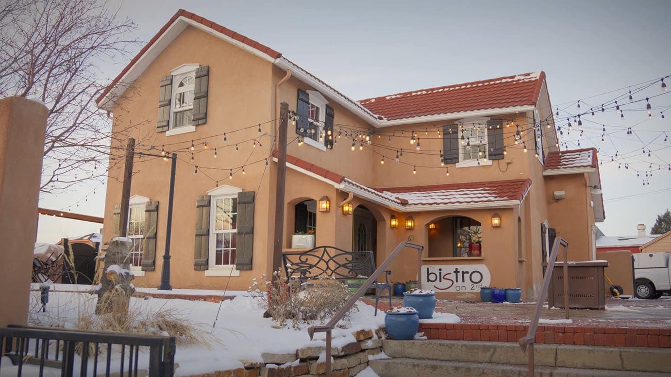 The Bistro on 2nd, a fine-dining restaurant in Monument, Colorado, strung with patio lights at dusk