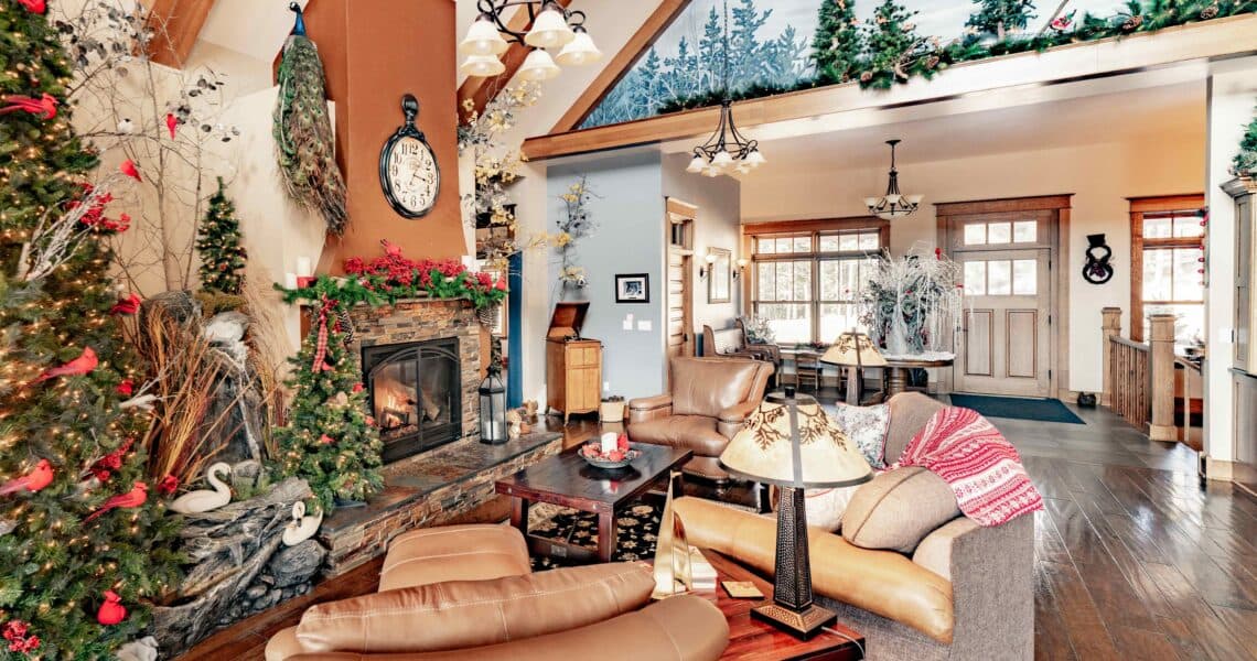 Cozy lodge living room with a stone fireplace and warm wood beams at Edgewood Inn in Woodland Park, Colorado