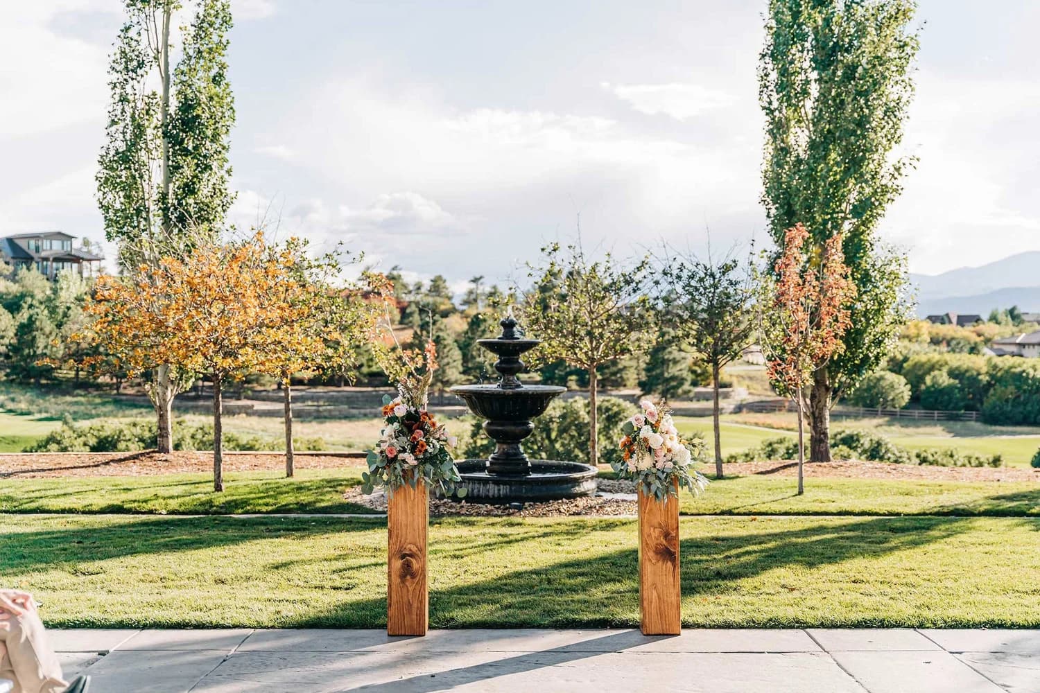 Outdoor ceremony arch framing a fountain with mountain views at Flying Horse Resort & Club in Colorado Springs, Colorado