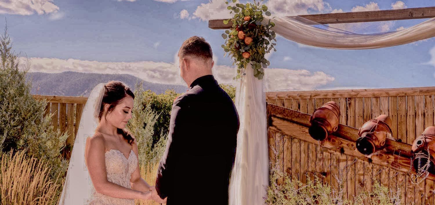 Outdoor wedding ceremony with a draped arch and mountain views at the Secret Window venue in Monument, Colorado