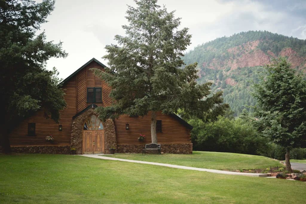 The historic brick lodge nestled against a forested hillside at Pinecrest in Palmer Lake, Colorado