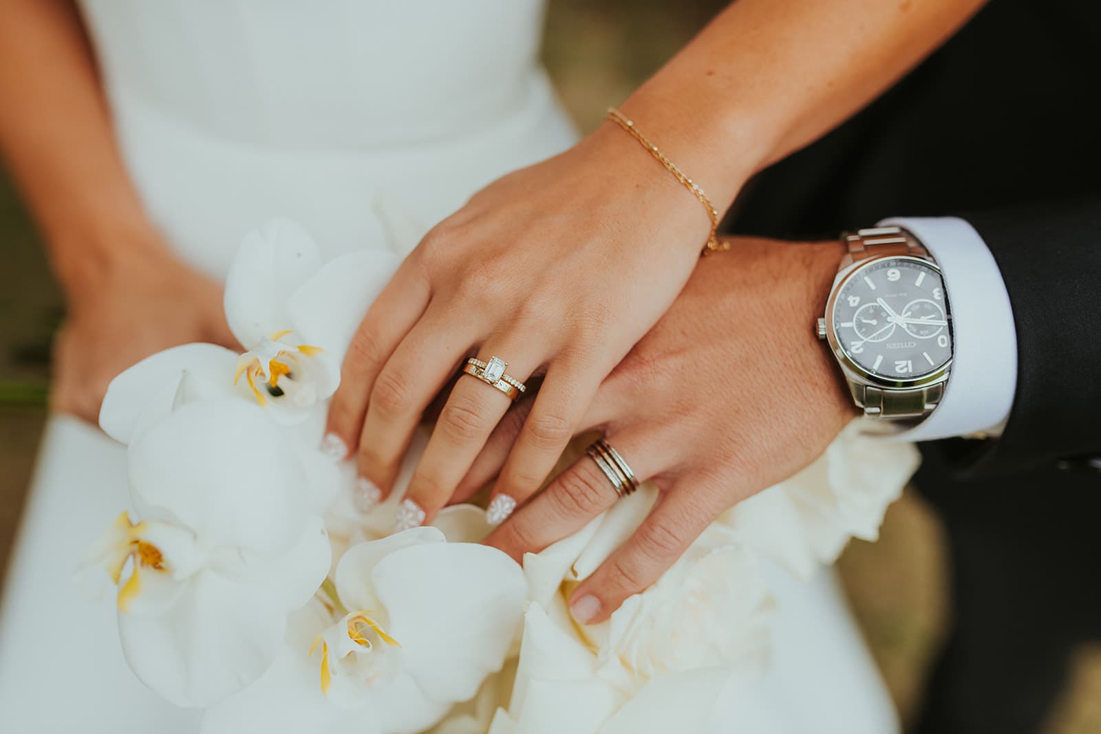 Close-up of the couple's wedding rings resting on white orchids at The Oaks at Plum Creek in Castle Rock, Colorado