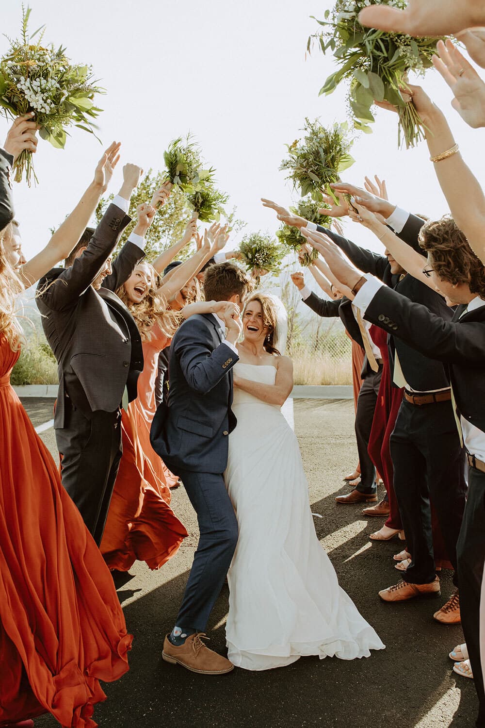 Wedding party celebrating the recessional with raised bouquets at The Pinery at the Hill in Colorado Springs, Colorado